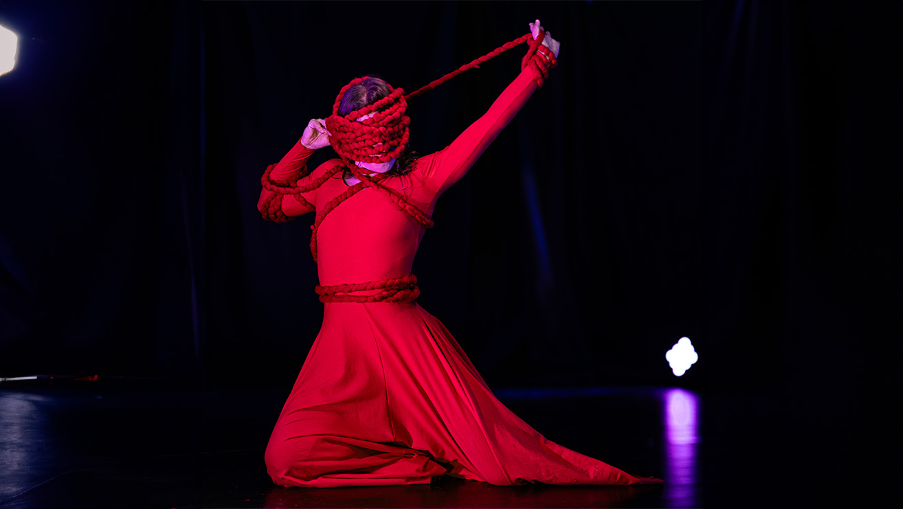 figura di danzatrice con volto mascherato in rosso